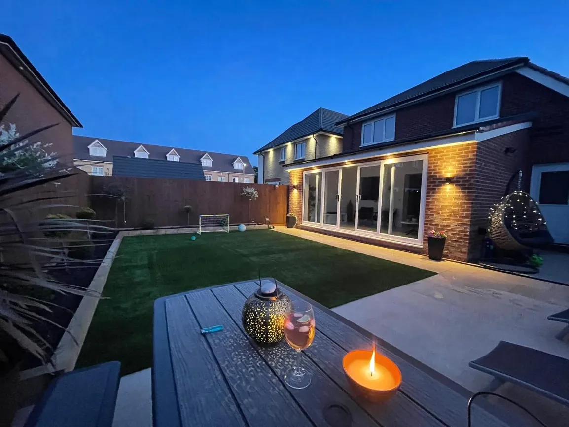 Completed rear house extension and patio garden at night by Liverpool builders Glassar Projects